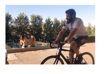 Dan Blizerian training on his bike by the pool with babes