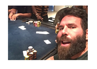 Dan Blizerian at the poker table taking a selfie. Nice stack of chips.
